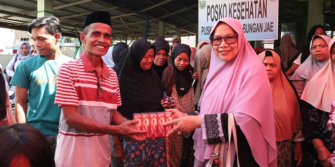Ketua TP PKK Madina menyerahkan santunan kepada anak yatim dan lansia di Desa Bangun Sejati